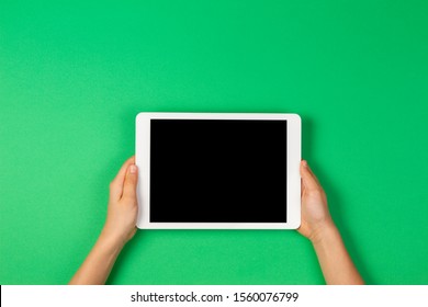 Child Hands Holding Tablet Computer On Light Green Background