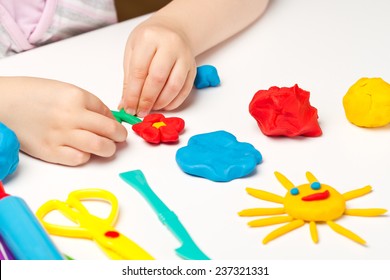 Child hands playing with colorful clay - Shutterstock ID 237321331