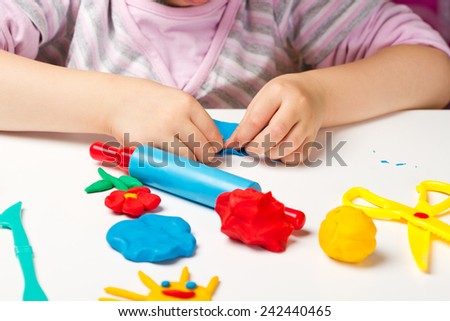 Child hands playing with colorful clay