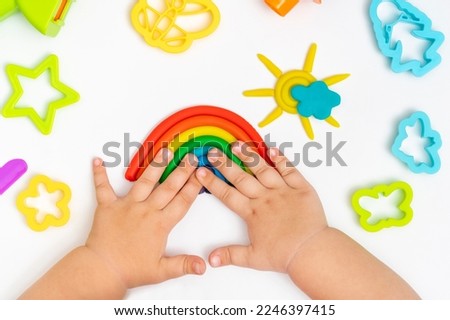 Child hands playing with colorful plastiline. Girl molding modeling play dough.