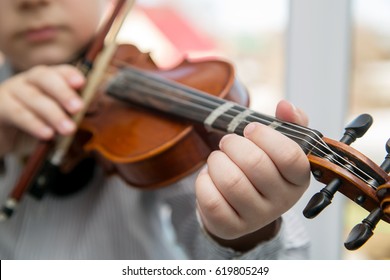 Child Hands Playing The Violin