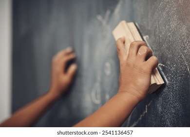 Child, hands and student with duster on chalkboard for erase, redo or learning at school. Closeup, kid or learner cleaning blackboard for education, childhood development or mistake in classroom - Powered by Shutterstock