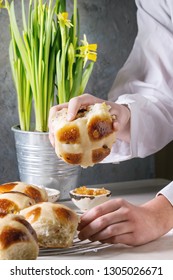 Child Hands Take Homemade Easter Traditional Hot Cross Buns On Cooling Rack On White Marble Table With Narcissus Flowers.