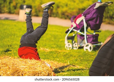 A Child Happily Tumbling In A Haystack.