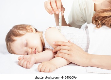 Child Has A High Temperature Or Fever. Sad Mother Measures The Temperature Of Baby Using A Thermometer. Closeup. Flu.