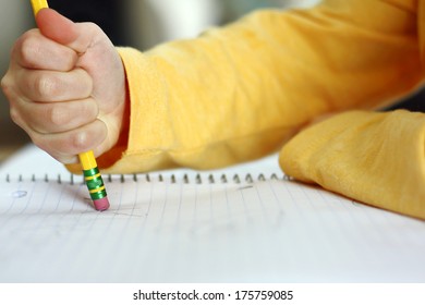 A Child Has Made A Mistake While Writing And Is Holding A Pencil And Erasing On White Notebook Paper