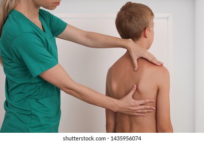 Child Having Chiropractic Back Adjustment. Osteopathy, Physiotherapy, Kinesiology. Bad Posture Correction