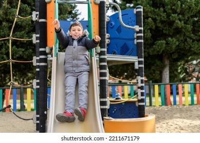 Child Having Fun Going Down A Slide At A Playground