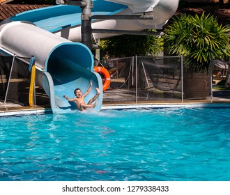 Child Having Fun On A Water Slide