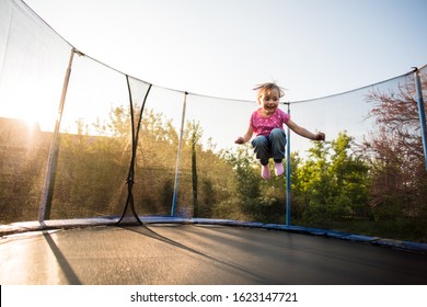 Child having fun as she jumps off the trampoline taut