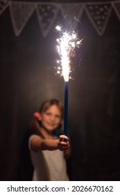 Child having fun while celebrating Christmas at home, holding and waving with a sparkler