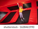 Child having fun while jumping on trampoline in fitness center