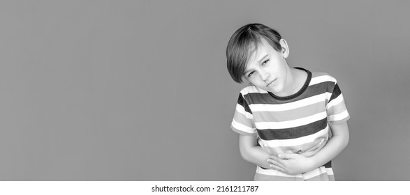 Child Having Terrible Pain In Stomach. Diarrhea Or Gastroenteritis Health Problem. Child Has Stomachache With Food Poisoning. Child Holding Hands On Belly. Black And White.