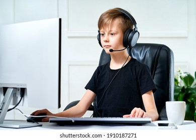 Child In Headphones Looks At A Personal Computer Monitor, Streams Plays A Computer Game, Broadcasts Online With Web Camera