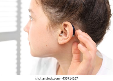 A Child With A Hearing Aid. The Girl Assumes Hearing Aid.