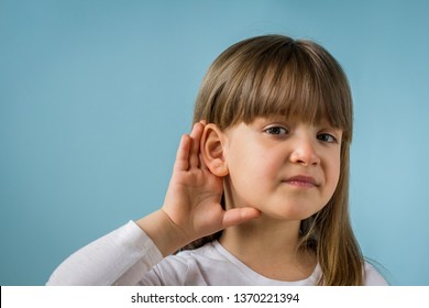 Child With Hearing Problem On Blue Background. Hearing Loss, Symptoms And Treatment Concept. Close Up, Copy Space.