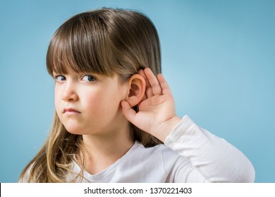 Child With Hearing Problem On Blue Background. Hearing Loss In Childhood, Symptoms And Treatment Concept. Close Up, Copy Space.
