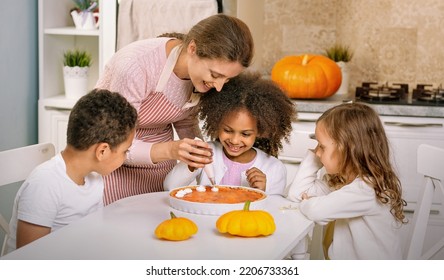 The child helps the mother to cook pumpkin pie. An American family. Single mother. Household chores for children. - Powered by Shutterstock