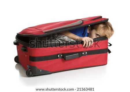 Child hiding inside a red suitcase. Isolated on a white background.