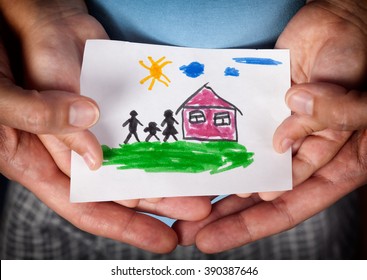 Child and his mom holding a drawn house with family. Close up. Vignette.