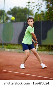 Child hitting the ball with the backhand on a dross court