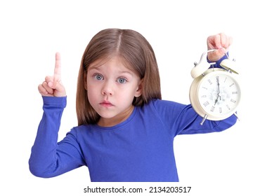Child holding alarm with 7 o'clock on clock face, concept to wake up early and holding forefinger up , isolated on white background looking at camera waist up caucasian little girl of 5 years in blue