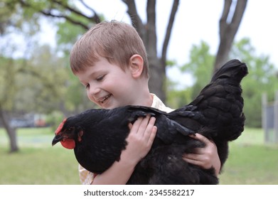 A child holding a backyard chicken