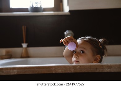 Child Holding Bath Bomb. Relaxing Hygiene Procedure For Kids. Aromatherapy And Fun At Home. Happy Toddler Girl In Bathtub Washing Herself