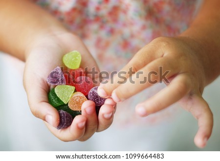   Child holding candy , jelly in hand                            