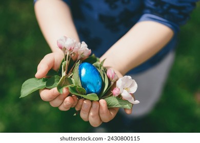 Child holding Easter eggs. Children are looking for Easter eggs in nature in the grass. Hunting for Easter eggs - Powered by Shutterstock