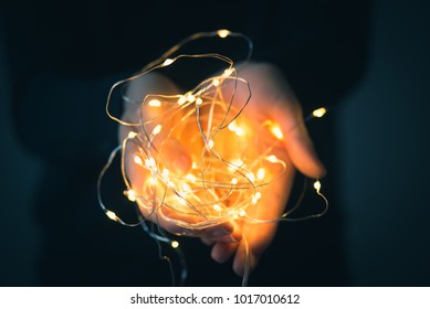 Child Holding Fairy Lights In His Hands