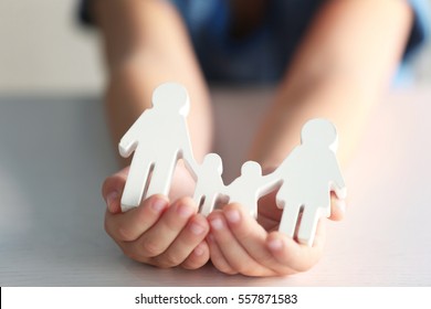 Child Holding Figure In Shape Of Happy Family, Closeup. Adoption Concept