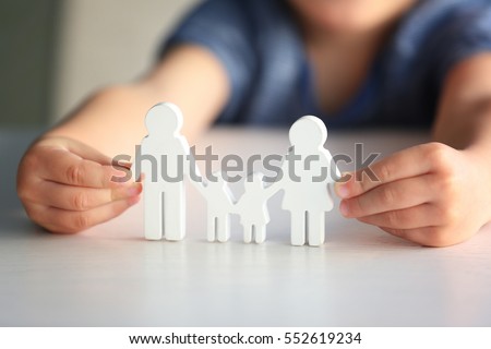 Child holding figure in shape of happy family, closeup. Adoption concept