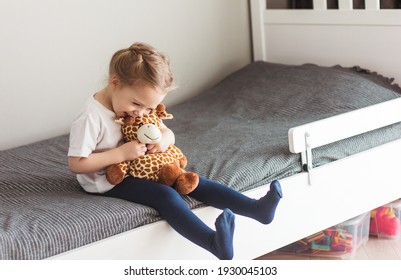 Child  Holding A Giraffe Plush Toy On A Gray Background