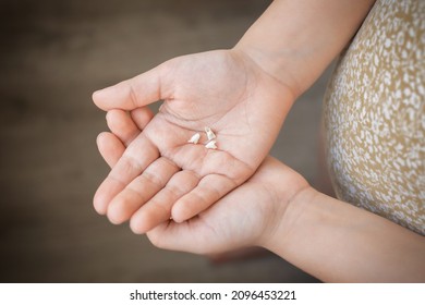 A Child Holding Milk Tooth In Palm Of Hand, Close Up