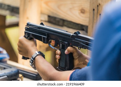 Child Holding Polish PM Rak Submachine Gun. Target Practice. Firearm Training At Outdoor Shooting Range. Horiozntal Shot. High Quality Photo