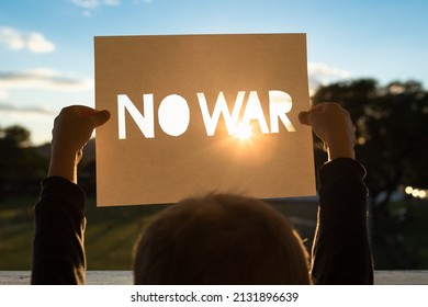 Child Holding Up Sign That Says No War. World Peace Concept 