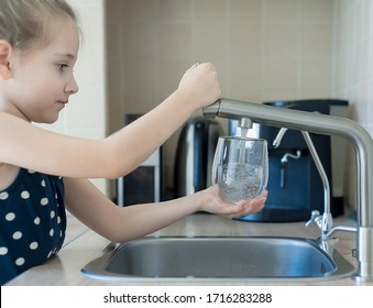 Child Is Holding A Transparent Glass. Filling Cup Beverage. Pouring Fresh Drink. Consumption Of Tap Water Contributes To The Saving Of Water In Plastic Bottles And To The Protection Of The Environment