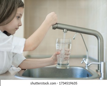 Child Is Holding A Transparent Glass. Filling Cup Beverage. Pouring Fresh Drink. Consumption Of Tap Water Contributes To The Saving Of Water In Plastic Bottles And To The Protection Of The Environment