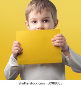 Child Holding A Yellow Paper Sheet