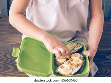 The Child Holds The Container With Sweet Sandwiches. Kids Snack In The Hands Of A Child. Selective Focus