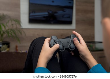 A child holds a controller while playing a console video game on a television.