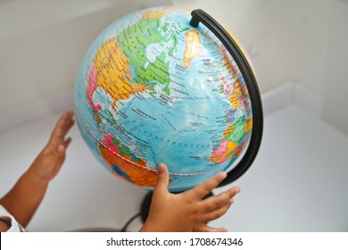 A Child Holds A Globe In His Hands. Protecting Planet Earth From Global Problems. Earth In The Hands Of A Child. Life Style. New Generation. A Child Examines The Country. Distance Learning