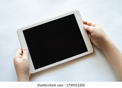 A child holds a tablet phone in his hands on a white background. - Powered by Shutterstock