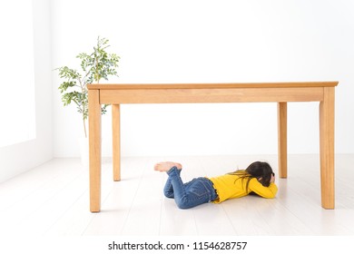 Child Huddling Under A Table