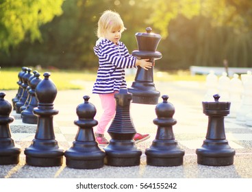 Child With Huge Chess Figures Outdoor