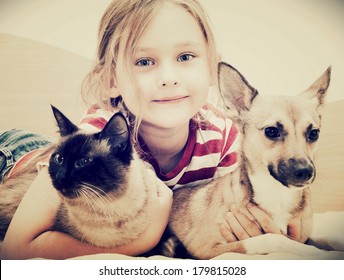 Child Hugging A Cat And Dog 