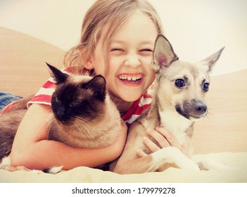Child Hugging A Cat And Dog 