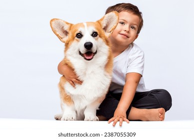 child hugging corgi dog on white background - Powered by Shutterstock