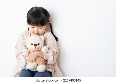 A child hugging a stuffed bear